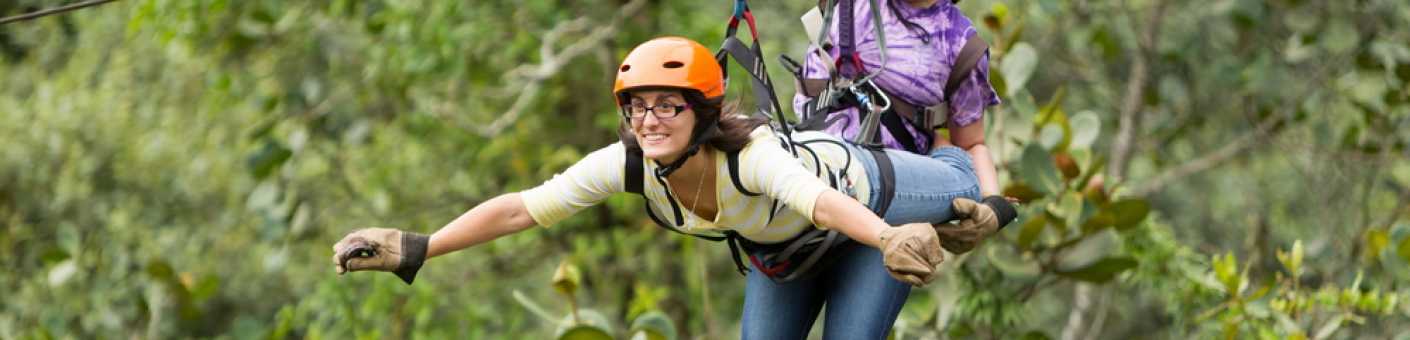 Two women going down a zipline showing signs of excitement and happiness at Branching Out in Halland, East Sussex